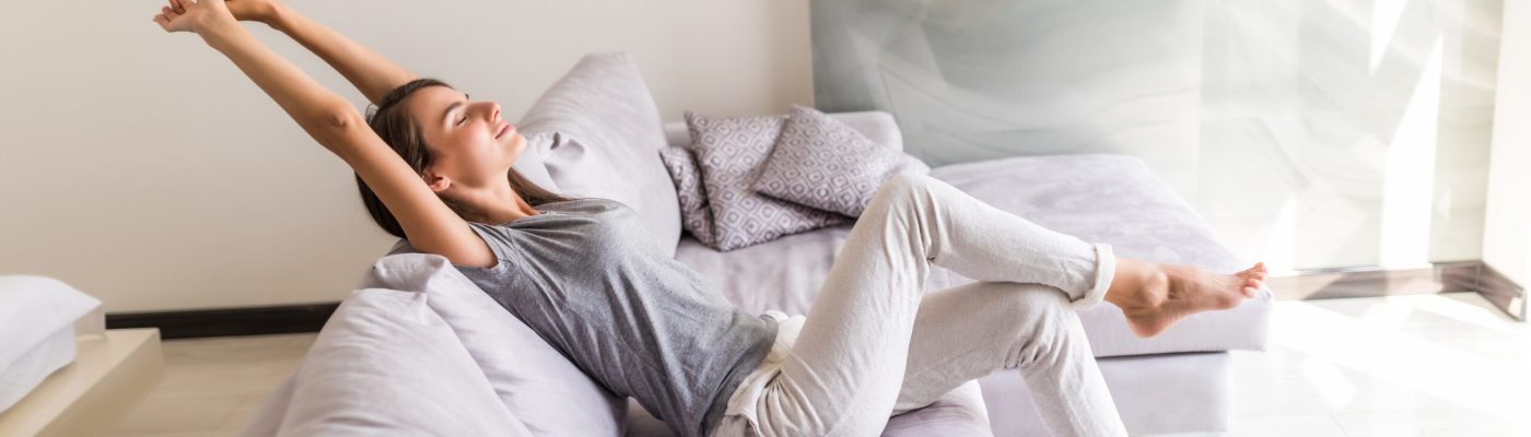 Closeup of a smiling young woman lying on couch